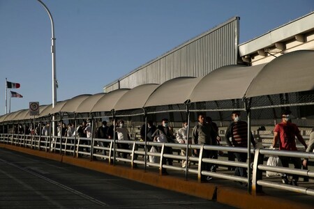 Mexican immigrants walk across the Paso del Norte border bridge after being deported from the United States amid the spread of the coronavirus disease (COVID-19), in Ciudad Juarez, Mexico April 21, 2020. REUTERS/Jose Luis Gonzalez