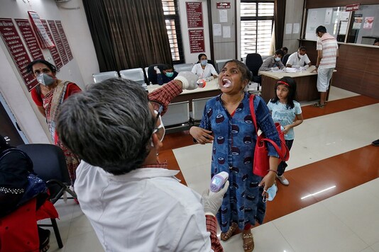 A doctor examines a woman at a government office building on the outskirts of Ahmedabad in Gujarat. (REUTERS)