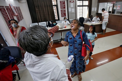 A doctor examines a woman at a government office building on the outskirts of Ahmedabad in Gujarat. (REUTERS)