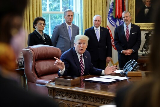 US President Donald Trump talks to reporters after signing the Paycheck Protection Program and Health Care Enhancement Act financial response to the coronavirus disease in the Oval Office at the White House in Washington. (Reuters)