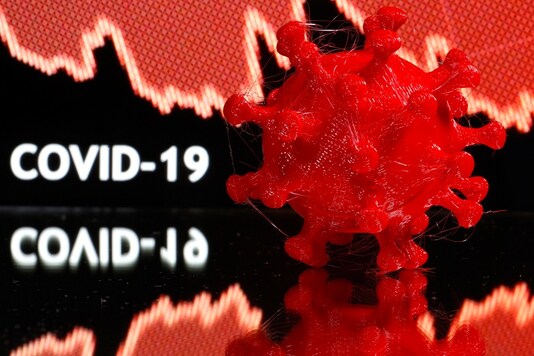 A 3D-printed coronavirus model is seen in front of a stock graph and the words Covid-19 on display in this illustration. (Reuters)