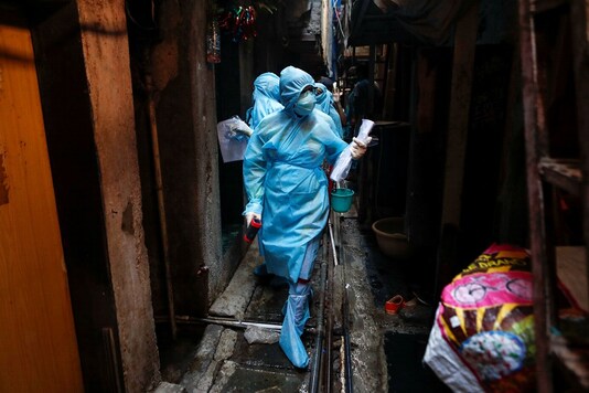 Healthcare workers enter a residential area to conduct swab tests in Mumbai. REUTERS/Francis Mascarenhas 