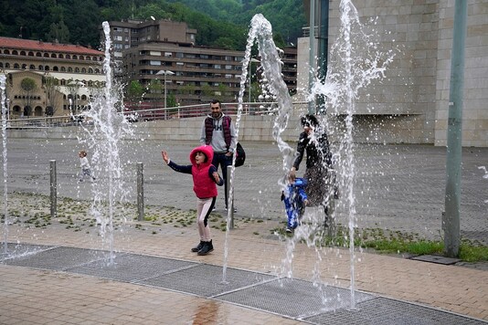 A girl plays in a fountain at the Guggenheim Museum, after restrictions were partially lifted for children for the first time in six weeks, during the coronavirus disease (COVID-19) outbreak in Bilbao, Spain, April 26, 2020. REUTERS/Vincent West - RC29CG9FJEJI