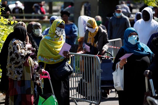 Residents arrive to collect soap, vegetables, fruits and other staples distributed by volunteers from community organizations in Clichy-sous-Bois, a suburb north of Paris.

 (AP Photo/Francois Mori, File)