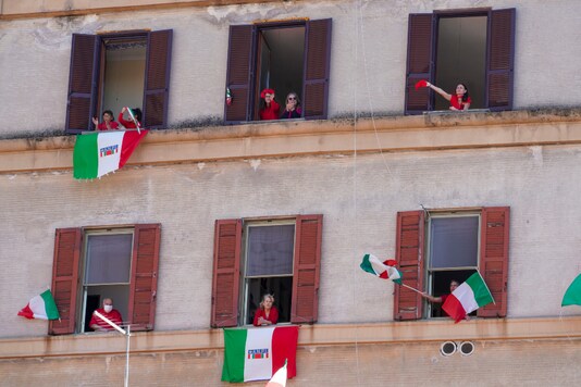 People wave and chant from their windows with the Italian flags draped on the occasion of the 75th anniversary of Italy's Liberation Day, in Rome, Saturday, April 25, 2020.  (AP)