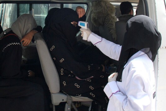 A health worker takes temperature of passengers of a van, amid fear of coronavirus disease (COVID-19), on the outskirts of Taiz, Yemen April 12, 2020. (Reuters)