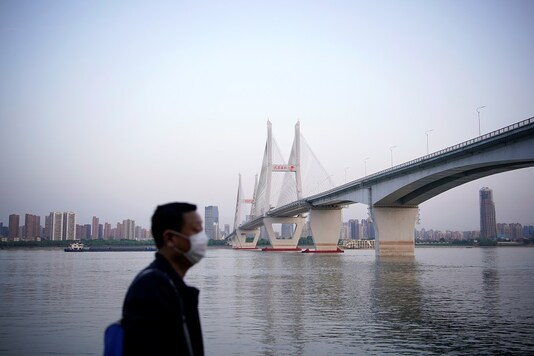 A man wearing a face mask is seen under a bridge of Yangtze river in Wuhan after the lockdown was lifted in Wuhan, capital of Hubei province and China's epicentre of the novel coronavirus disease (COVID-19) outbreak. (Reuters)