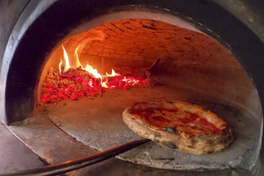 Pizzas are being prepared for home delivery at the Caputo pizzeria in Naples, Monday, April 27, 2020. Region Campania allowed cafes and pizzerias to reopen for delivery Monday, after a long precautionary closure due to the coronavirus outbreak. (AP Photo/Andrew Medichini)