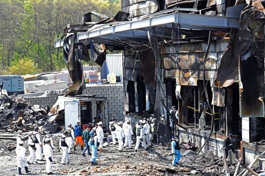 Police investigators enter to inspect a burnt construction site after a fire in Icheon, South Korea, Thursday, April 30, 2020. One of the South Korea's worst fires in years broke out on Wednesday at the construction site. (Hong Ki-won/Yonhap via AP)