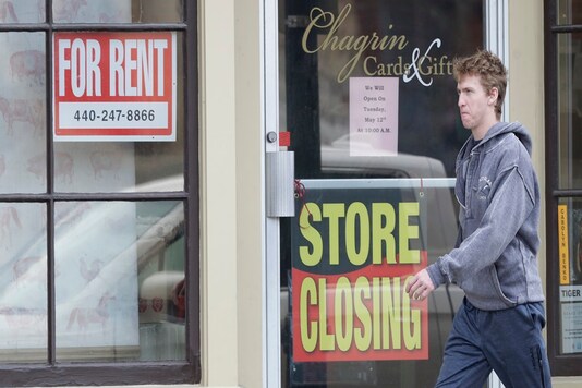 A man walks past a closed business, Wednesday in Chagrin Falls, Ohio. 

(AP Photo/Tony Dejak)