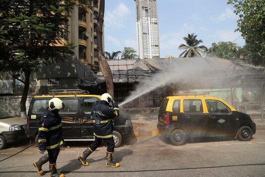 Fire brigade personnel sanitize an area as part of precautionary measures against the new coronavirus in Mumbai, Maharashtra. (AP)