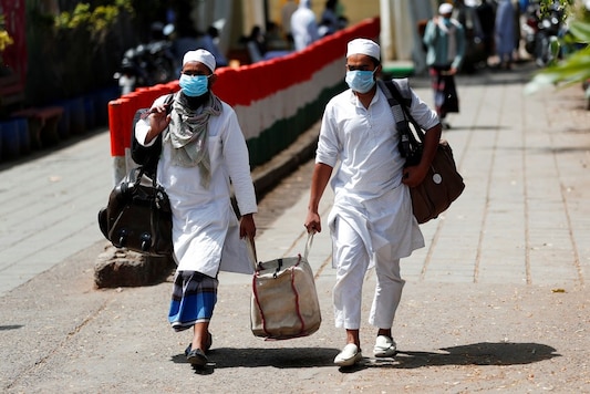File photo: Men wearing protective masks walk as they carry bags, amid concerns about the spread of coronavirus disease (COVID-19), in Nizamuddin, area of New Delhi. (Reuters) File photo: Men wearing protective masks walk as they carry bags, amid concerns about the spread of coronavirus disease (COVID-19), in Nizamuddin, area of New Delhi. (Reuters)