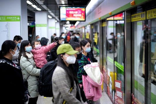 People wearing face masks wait for a subway train on the first day the city's subway services resumed following the novel coronavirus disease (COVID-19) outbreak, in Wuhan of Hubei province, the epicentre of China's coronavirus outbreak, March 28, 2020. The Chinese characters  REUTERS/Aly Song - RC2SSF9L5ZYZ