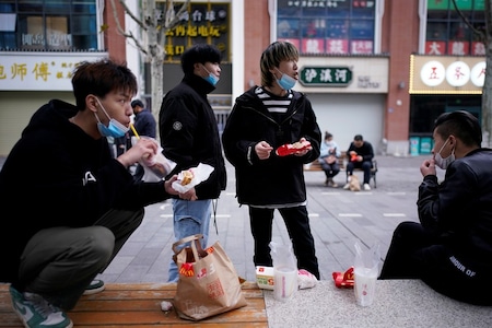 People wearing face masks eat outside a McDonald's restaurant in Wuhan, Hubei province.

 REUTERS/Aly Song - RC2AUF98BAC6