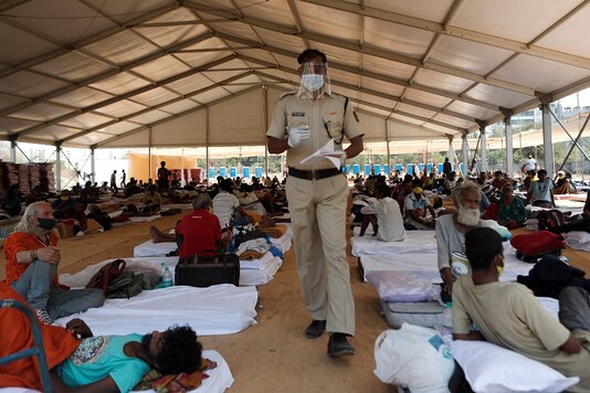 A policeman wearing a protective mask walks inside a shelter set up for migrants during a 21-day nationwide lockdown to limit the spreading of coronavirus disease (COVID-19) in Mumbai.