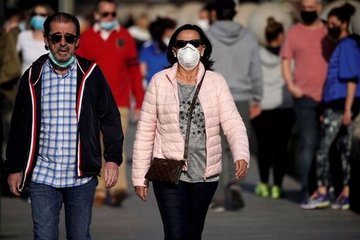 File photo of people in protective face masks walking on the Bridge of Segovia amid the coronavirus disease (COVID-19) outbreak, in Madrid, Spain. (Reuters)