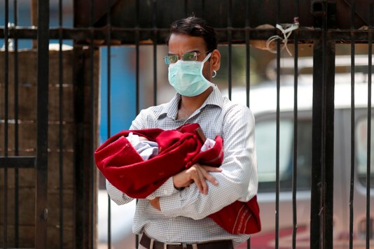 For representation: A man holding his 10 days old child waits for tests for both of them at a mobile testing center, during an extended nationwide lockdown to slow the spread of the coronavirus disease (COVID-19), in New Delhi, India, May 2, 2020. REUTERS/Adnan Abidi