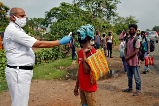 A cop checks the temperature of a migrant worker in Kolkata. (Reuters)