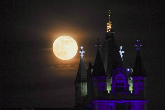 The supermoon rises behind Tower Bridge, in London, Thursday, May 7, 2020. The supermoon is a phenomenon that happens when the moon is at its closest point to the earth and looks larger than usual. (AP Photo/Alberto Pezzali)