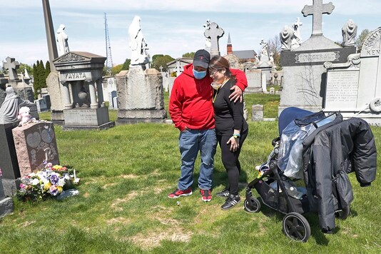 Israel Rodriguez embraces his ex-wife Sharon Rivera as the pair stand in front of their daughter Victoria's grave after a chance encounter at Calvary Cemetery on Mother's Day in New York. (AP Photo)
