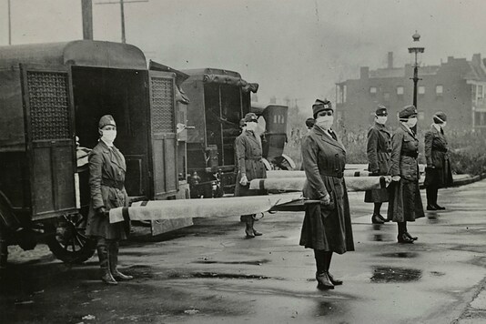 Mask-wearing women hold stretchers near ambulances during the Spanish Flu pandemic in US in October 1918. (Library of Congress/Handout via Reuters)