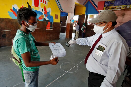 An official inspects a man's ticket in Ahmedabad before he boards a train. (Reuters)