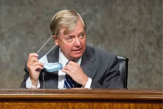 Chairman Lindsey Graham, R-S.C., takes off his mask as he arrives for the Senate Judiciary Committee hearing on 