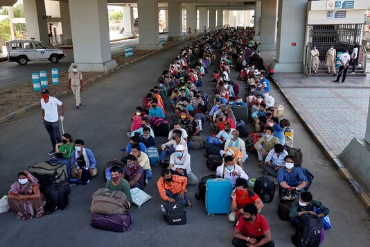 Migrant workers and their families wait for transport to reach to a railway station to board trains to their home state of eastern Bihar, in Ahmedabad, India, REUTERS/Amit Dave