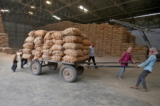 Labourers move a cart loaded with rice bags inside a food processing unit, which was reopened after weeks-long shutdown to slow the spread of coronavirus disease (COVID-19), on the outskirts of Ahmedabad, India, April 20, 2020. REUTERS/Amit Dave