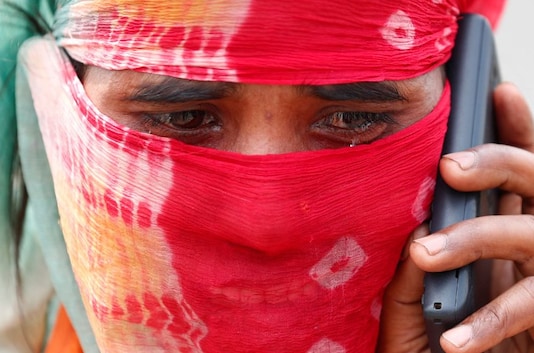 The wife of a migrant worker cries as she talks to a relative on a mobile phone after police stopped them at a checkpoint while they were walking on a highway to return to their home state in the northern state of Uttar Pradesh, during an extended nationwide lockdown to slow the spread of the coronavirus disease (COVID-19), in Ghaziabad, in the outskirts of New Delhi. (Image: Reuters)