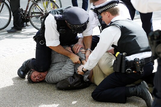 A protester is detained by police officers during a demonstration in Hyde Park, following the outbreak of the coronavirus disease (COVID-19), London, Britain, May 16, 2020. REUTERS/Peter Nicholls
