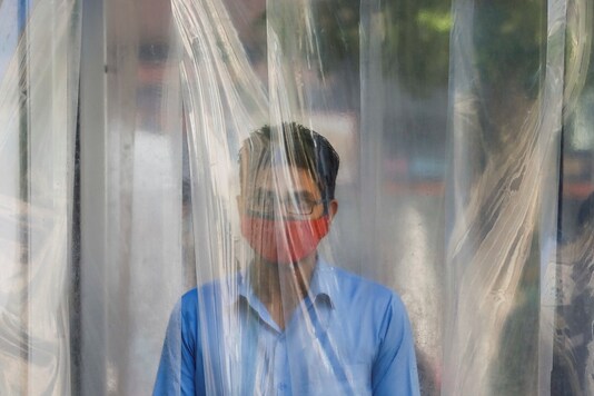 A man wears a protective mask as he gets sanitized before entering a shopping mall, after Pakistan started easing the lockdown restrictions, amid the coronavirus disease (COVID-19) outbreak, in Karachi, Pakistan May 18, 2020. REUTERS/Akhtar Soomro