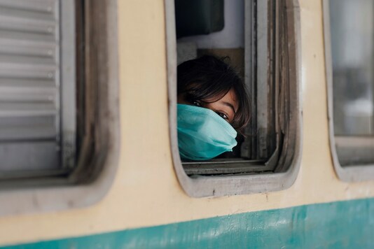 A girl wearing a protective mask looks out from a train window as she returns to her hometown, after Pakistan started easing the lockdown restrictions and allowed to resume passenger trains, following the coronavirus disease (COVID-19) outbreak, in Karachi. (Reuters)