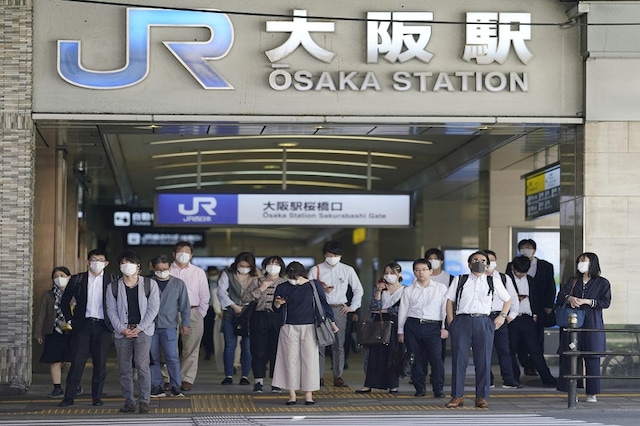 Commuters wearing protective masks head to work amid the coronavirus disease (COVID-19) outbreak in Osaka, Japan in this photo taken by Kyodo Mandatory credit Kyodo/via REUTERS