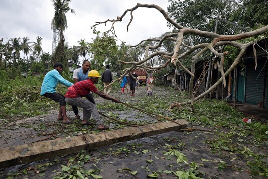 File photo: Men remove a fallen electricity pole from a road after cyclone Amphan made its landfall in South 24 Parganas district on West Bengal on Thursday. (Reuters)
