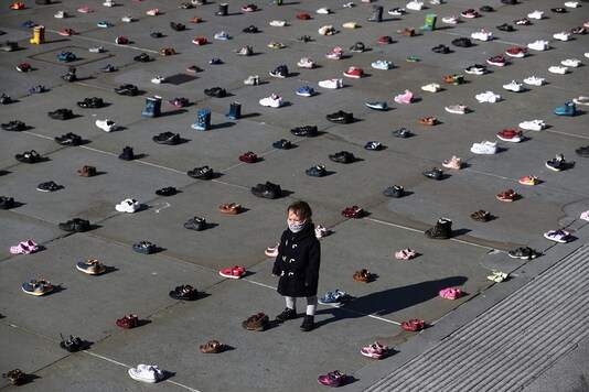 A child wearing a face mask stands surrounded by shoes in London, Britain. (Reuters)