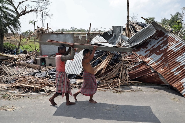 Residents carry tin sheets salvaged from the rubble of a damaged house in the aftermath of Cyclone Amphan, in South 24 Parganas district in West Bengal, India, May 22, 2020. REUTERS/Rupak De Chowdhuri