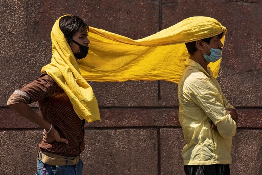 Migrant workers cover themselves with a scarf to protect from the heat in New Delhi. (Reuters)