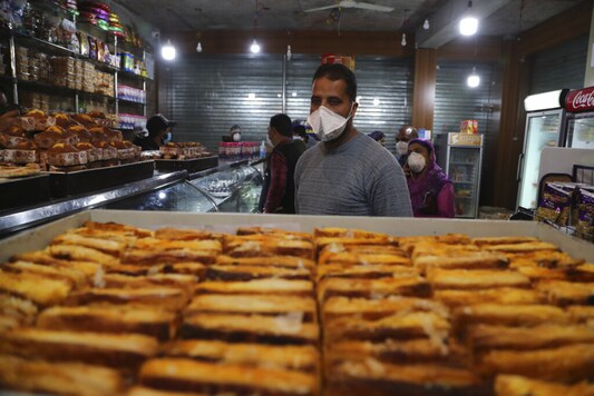 A Kashmiri man wearing a mask shops at a bakery ahead of Eid al-Fitr during a nationwide lockdown to control the spread of coronavirus, in Srinagar. (Image: AP)