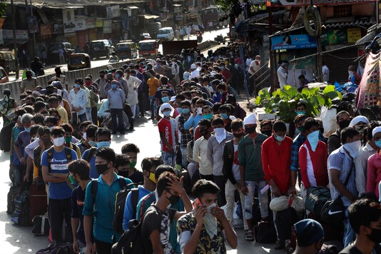 Migrant workers line up to board buses for their onward journey by train to their home states, at Dharavi, one of Asia's largest slums, in Mumbai (AP Photo/Rafiq Maqbool)