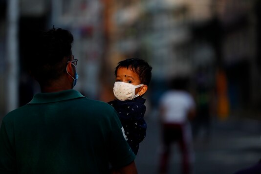 A Nepalese man carries his child as they return from a market during lockdown in Kathmandu, Nepal, Sunday, May 17, 2020. (AP Photo/Niranjan Shrestha)