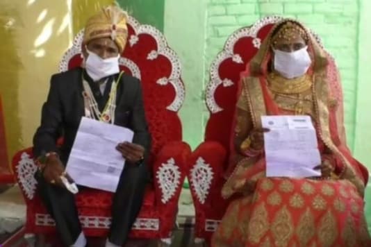 The bride and groom with their COVID-19 test reports. (News18) The bride and groom with their COVID-19 test reports. (News18)