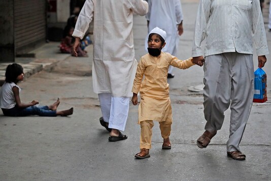 A Muslim boy with his father walks back home after Eid al-Fitr paryers were not allowed at Jama Masjid during a lockdown to control the spread of coronavirus at the old quarters of New Delhi on Monday. (AP)