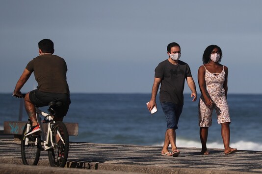 A couple walks next to Leblon beach, amid the coronavirus disease (COVID-19) outbreak in Rio de Janeiro, Brazil. REUTERS/Sergio Moraes