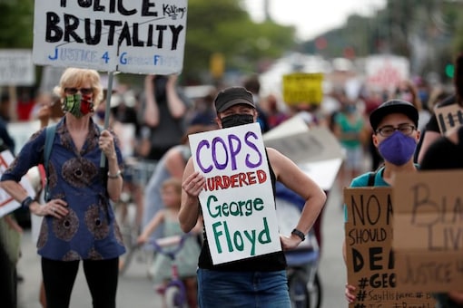 Protesters gather at the scene where George Floyd, an unarmed black man, was pinned down by a police officer kneeling on his neck before later dying in hospital in Minneapolis, Minnesota, U.S. May 26, 2020. REUTERS/Eric Miller/File Photo