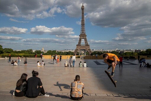 People stroll at Trocadero square near the Eiffel Tower in Paris, Monday, May 25, 2020, as France gradually lifts its Covid-19 lockdown. In Paris, where all city parks remain closed, residents stroll along the Seine river and outside the Tuileries Gardens. (AP Photo/Michel Euler)