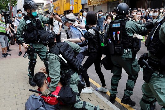 FILE PHOTO: Anti-government demonstrators scuffle with riot police during a lunch time protest as a second reading of a controversial national anthem law takes place in Hong Kong,  2020. REUTERS