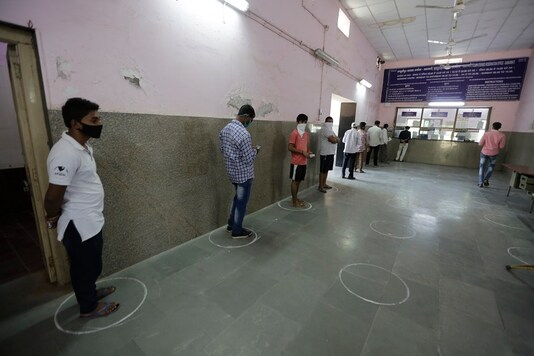 Indians stands in marked positions to observe social distancing as they wait to buy tickets at Sabarmati Railway station. (AP Photo/Ajit Solanki)
