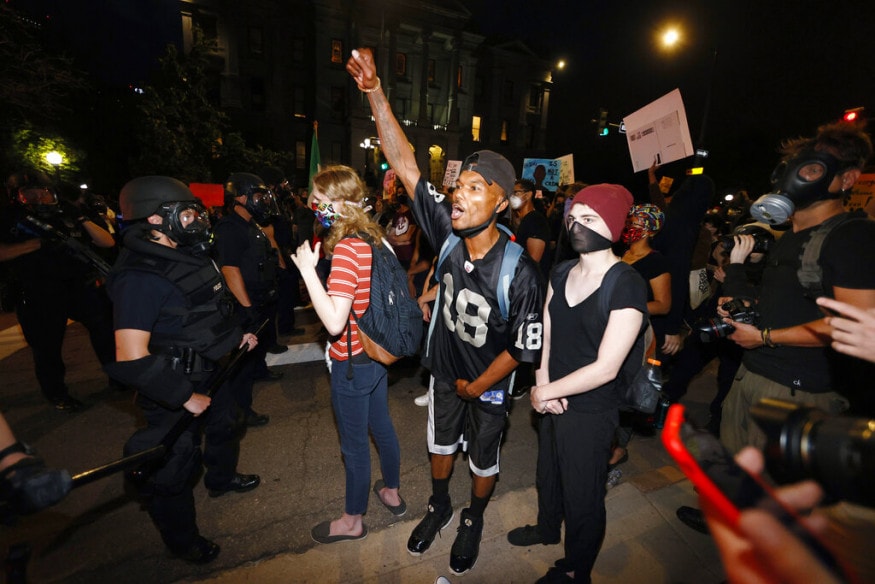  Denver police stand in front of protesters outside the State Capitol during a demonstration over the death of George Floyd, a handcuffed black man in Minneapolis police custody, in Denver. (Image: AP)