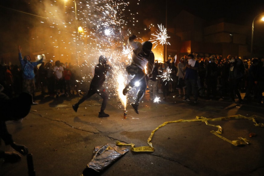  Protesters set off fireworks as a fire burns at the Minneapolis police 3rd Precinct building, in Minneapolis. (Image: AP)